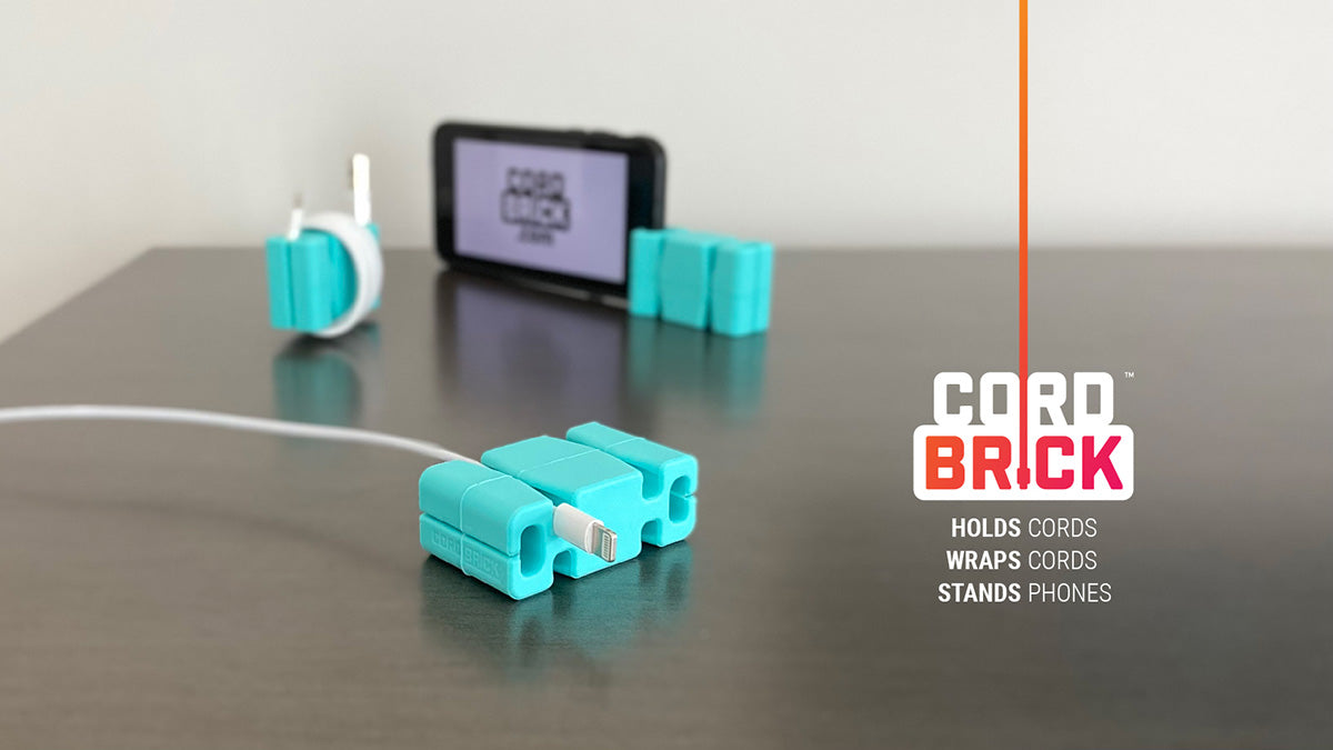Three aqua colored CordBricks® with the front middle one holding an Apple iPhone cord, one wrapping a similar charger cable and one standing a phone. The CordBrick logo, and "holds cords, wraps cords, stands phones" written below.