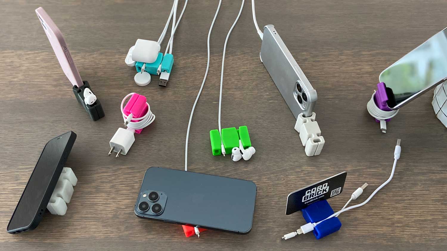 Photo showing the variety of uses for CordBrick with cords, phones, and AirPods. Holding and wrapping cords plus standing, propping, and easy access to your most used devices.