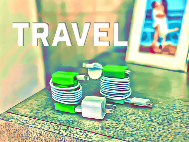 Travel (in text) with two green CordBricks wrapping several white charger cords on a tan hotel nightstand.