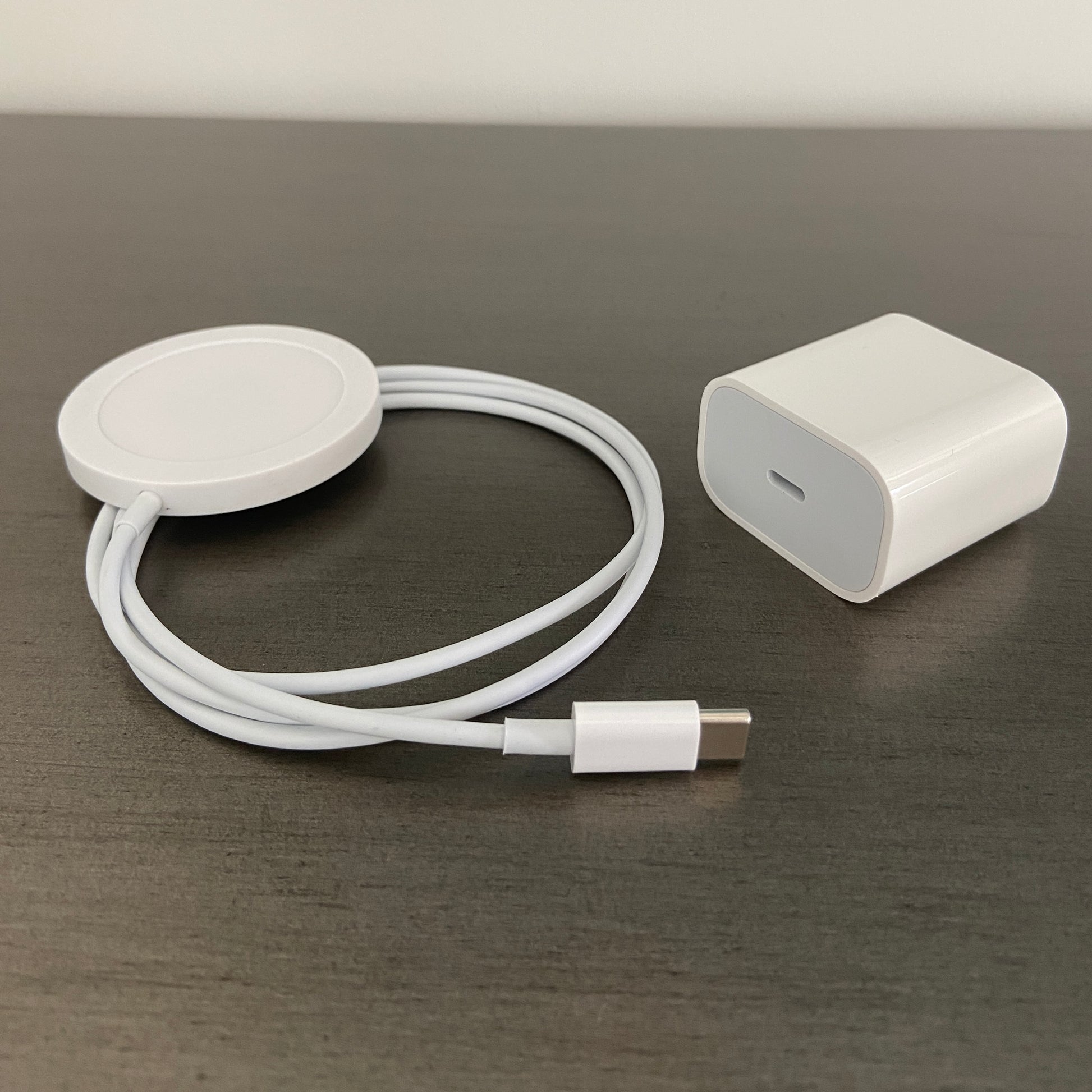 White wireless charger cord and wall brick on a gray table